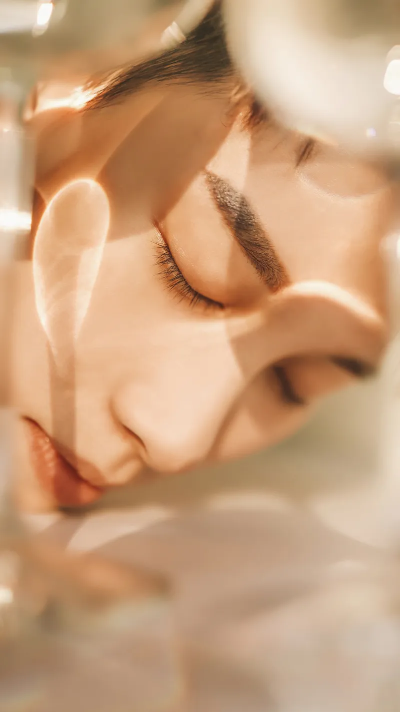 Visage lumineux, la main posée sur la joue, dans une lumière dorée